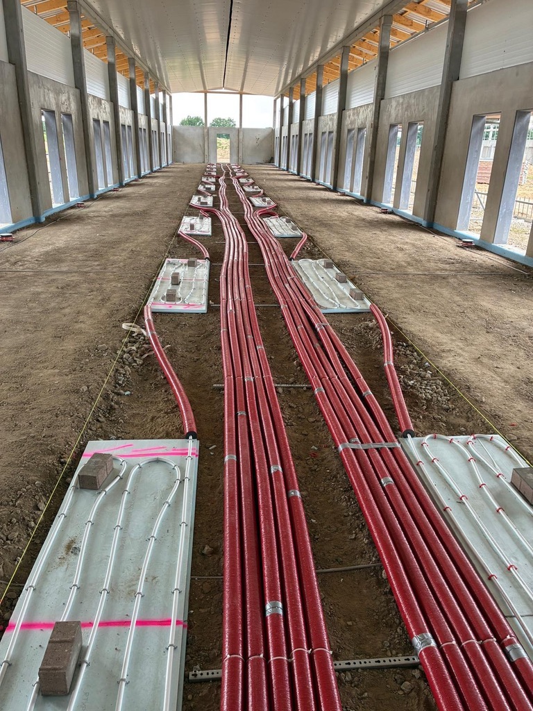 Verlegte Fußbodenheizungsrohre auf dem Untergrund vor dem Betonieren