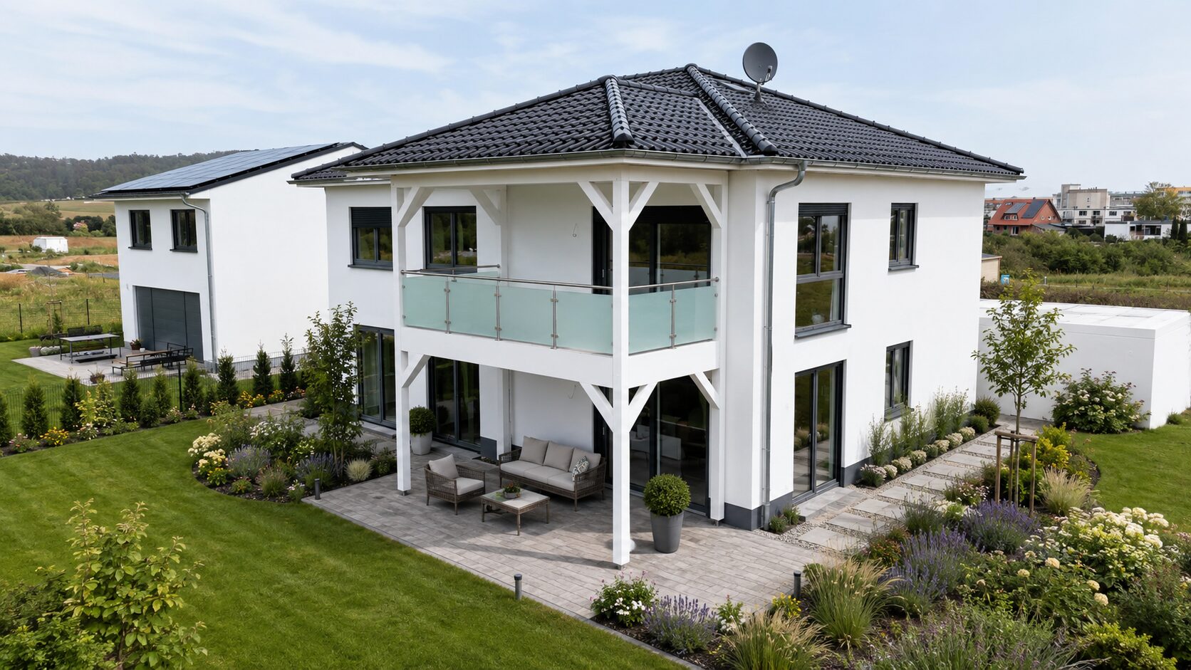 Modernes verputztes Wohnhaus mit auskragendem Balkon auf Holzstützen